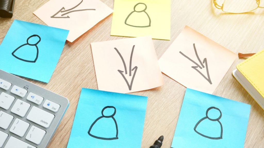 photo of sticky notes with people and arrows drawn on them and arranged in a flow-chart style